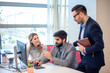 © Bojan - Three business people in serious discussion and thinking during meeting at computer in office