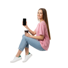 Smiling young woman using a phone while enjoying coffee against an isolated transparent area
