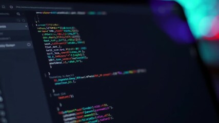 Computer Screen Displays Lines of Multicolored Code on Dark Background