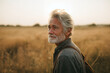 © Rodiego - Thoughtful senior white man with grey beard standing in golden wheat field at sunset