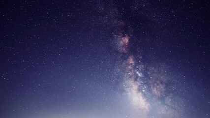 Wall Mural -  Starry sky timelapse background. Beautiful night sky with Milky Way galaxy on dark sky.