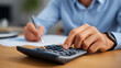 © Kateryna - Business professional using calculator with pen at office desk to manage personal finance including budgeting and debt repayment planning credit card payment businessman