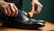 © miss irine - Man polishes shiny black leather dress shoe with small brush. Hands carefully clean formal footwear on wooden table. Daily grooming routine for classic elegant shoes, making pro, new looking for work