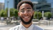 © liliyabatyrova - Mixed race man smiles in urban setting wearing smart casual attire during daytime