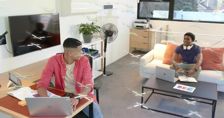 Wall Mural - Man pausing typing and turning to coworker, grabbing tablet and sharing screen for business review