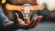© DreamyDesignsCo - Bright idea presented in hand symbolizing innovation, energy efficiency, and creative solutions for sustainable living and future technology projects