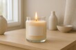 © Bijac - Clear glass candle jar burning in bright minimal interior with styled neutral home decor