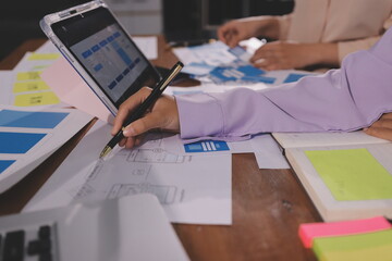 Close up ux developer and ui designer brainstorming about mobile app interface wireframe design on table with customer breif and color code at modern office.Creative digital development agency.