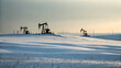 © FotoSphere - Silhouetted oil pump jacks operate on snow covered hills at sunset oil rig winter