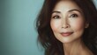 © Studicon - The image shows a middle-aged woman with shoulder-length brown hair and neutral-toned makeup, looking directly at the camera against a softly lit cyan background.