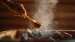 © tiagozr - Hand pouring water on hot sauna stones.