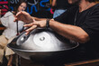 © ADDICTIVE STOCK - Man playing a handpan at a live music concert
