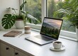 © Uhartist35 - Laptop and coffee by a window with lush green plants