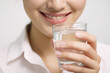 © Hazel - A woman holding a glass of clear water and smiling brightly