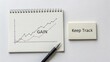© Hazarul - Business Growth Graph with Handwritten Gain Note and Pen on Notepad for Tracking Progress and Success in Financial Performance
