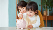 © 39LAB - Smiling child saving money with piggy bank and parent support