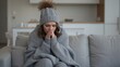 © Ramdan - Woman wrapped in a blanket trying to keep warm while sitting on the couch at home on a cold day