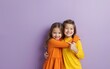 © li - Photo of lovely two little kids hugging point empty space dressed stylish orange yellow garment isolated on purple color background. High quality