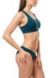 © Barny - Young caucasian woman, slender, in teal sports bra and bikini, posed in profile against transparent background with copy space. Concept of female body beauty and health