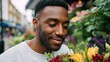 © iuricazac - Man smiling near flowers.