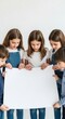 © Pindo - Group of five children, three girls and two boys, holding a blank white poster, looking down at it with curiosity.