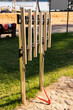 © Creative_Bird - Metal tubes stand in a park setting, inviting visitors to create music. Located near a sandy area and water, the setup encourages play and social interaction