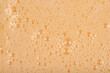 © nahhan - A full-frame, close-up shot captures the texture of a smooth, light beige liquid batter covered in tiny foam bubbles.