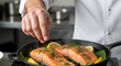 © Bisa - Chef seasoning sizzling salmon fillets with lemon and fresh dill in a cast iron skillet, delicious gourmet seafood recipe preparation at restaurant