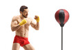 © Ljupco Smokovski - Man in red shorts practicing kickboxing with a punch stand