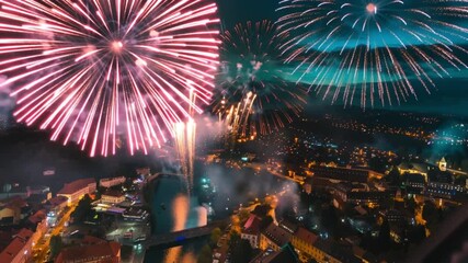 Colorful fireworks exploding over a city skyline at night, celebrating festive event.