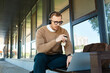 © LIGHTFIELD STUDIOS - Young university teacher engaged in online learning while enjoying coffee outdoors