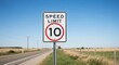© Dece Std - Rural highway speed limit 10 mph sign with fields, blue sky backdrop