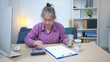 © Wosunan - On a holiday, an elderly woman record of household and personal income and expenses