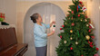 © Wosunan - On a holiday, an elderly woman enjoys decoration Christmas tree and playing the piano at home