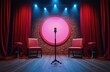 © Vadym - Dimly lit comedy club stage with red curtains, brick backdrop featuring microphone on stand, seating. Two red chairs, stools on wooden floor under spotlight. Performance setting for comedian humorist.