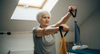 © SYATRI RAWU - Active senior woman strengthening her arms and upper body using a resistance band during a home workout for healthy aging and vitality