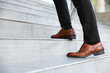 © New Africa - Man walking up stairs outdoors, closeup view