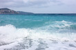 Beautiful view of wavy sea, city and pebbles on beach
