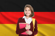 © New Africa - Student with backpack and notebooks against flag of Germany. Language school