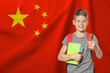 © New Africa - Little boy with backpack and stationery against flag of China. Language school