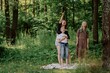 © looking2thesky - A young mother joyfully plays with her daughter and son in nature, sharing authentic family moments of laughter and connection. Pure love and outdoor happiness
