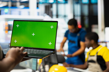 Black photovoltaics factory worker using isolated computer to optimize production of solar cells, renewable energy. Solar panels plant supervisor monitors manufacturing process on pc.