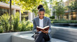 © MEO - Businesswoman sitting on a bench outdoors reading the Bible with joy and focus