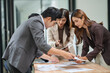 © aekachai - Group of businesspeople are standing in a meeting, exchanging knowledge in the office.