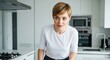 © mlangsen - Short-haired woman in bright modern white kitchen, looking intently at something unseen