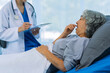 © ArLawKa - Doctor is examining elderly female patient in ward while doctor is checking her condition in recovery room. Medical and healthcare concept.