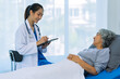 © ArLawKa - Doctor is examining elderly female patient in ward while doctor is checking her condition in recovery room. Medical and healthcare concept.