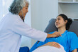 © ArLawKa - Senior female doctor holding stethoscope examining female patient checking heart rate, heart disease healthcare concept, female patient, proper care