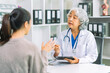 © ArLawKa - Doctor and patient discussing various matters while sitting at a table. Medical and healthcare concept. Doctor and patient.