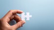 © Виктория Суханова - Hand holding a white puzzle piece symbolizing connection and solution finding. Represents teamwork, problem-solving, unity, completion, challenge, and finding answers in business.